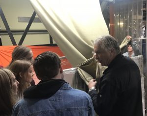 Students see fabric unrolling on a factory tour.