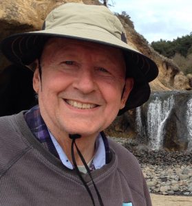 Photo of Curt Moulton in hat near waterfall