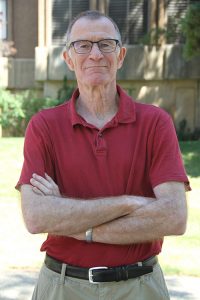 John Browse, standing outside, with arms crossed.