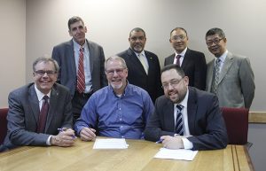 Group photo of signers, administrators at a table.