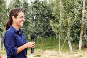 Sallato holding microphone in orchard.
