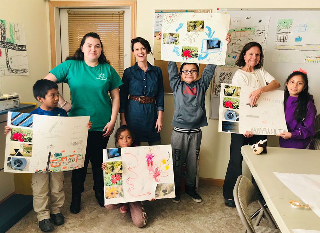A line of teachers, kids, and youth holding newly made posters.