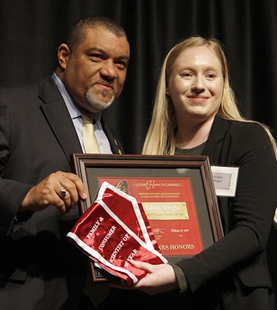 Wright, at right, accepts her sash and framed award from the Dean, left.