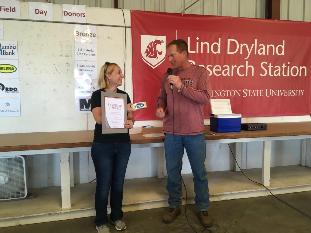 Crow, standing with Koenig,, holds certificate and can of cheese.