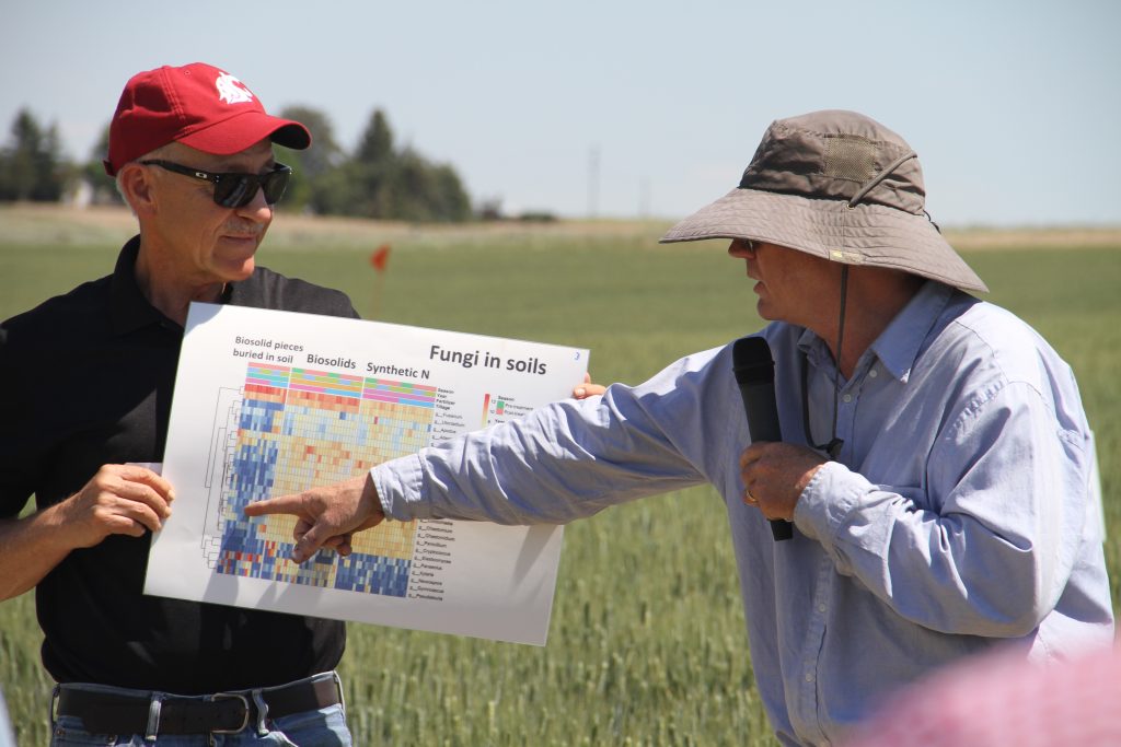 Paulitz, right, gestures at a colorful graphic held by Schillinger, left.