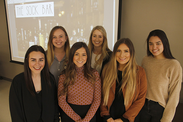 Group photo in front of Sock Bar title screen.