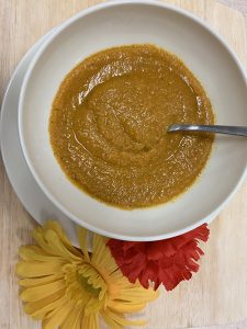 Bowl of porridge, with floral decorations and spoon.