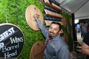 Winemaker signing mounted barrel bottom .