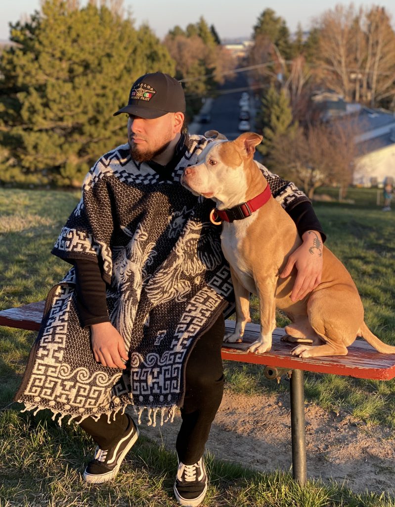 Navarro, seated on outdoors bench, with dog.