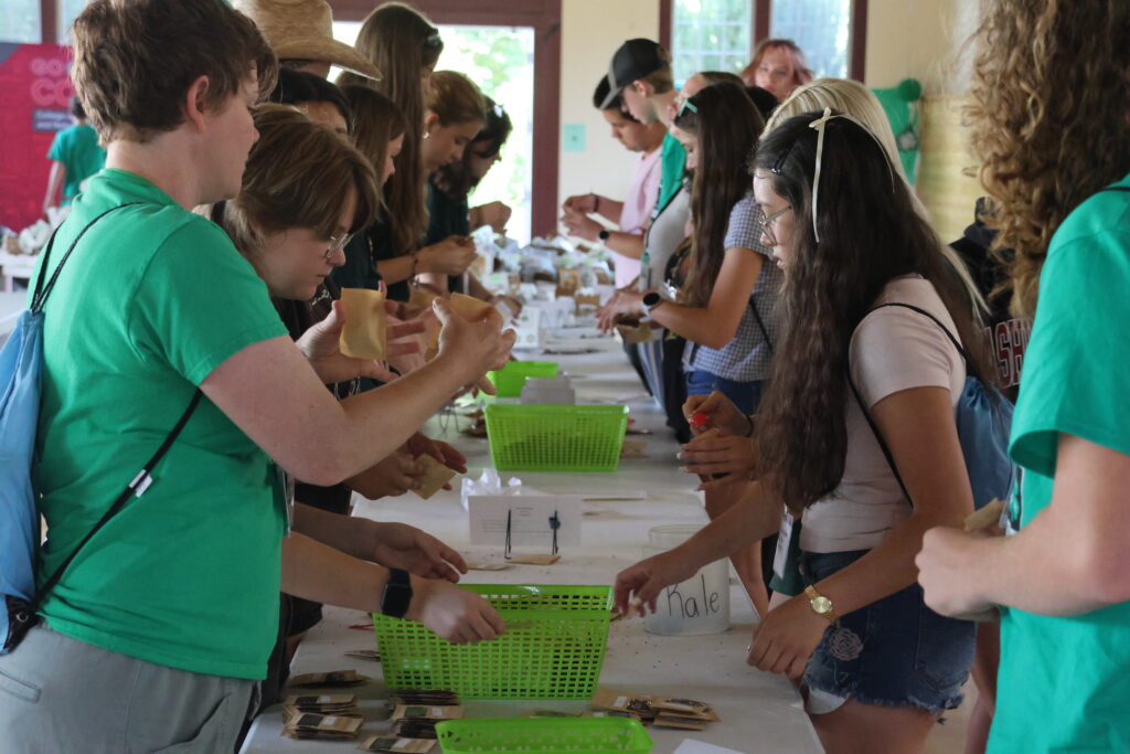 4-H teens work on a project at a long row of tables.