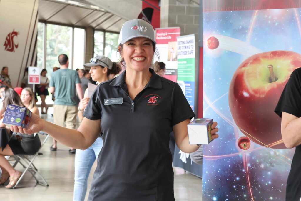 Denise holding boxed apples at move-in event