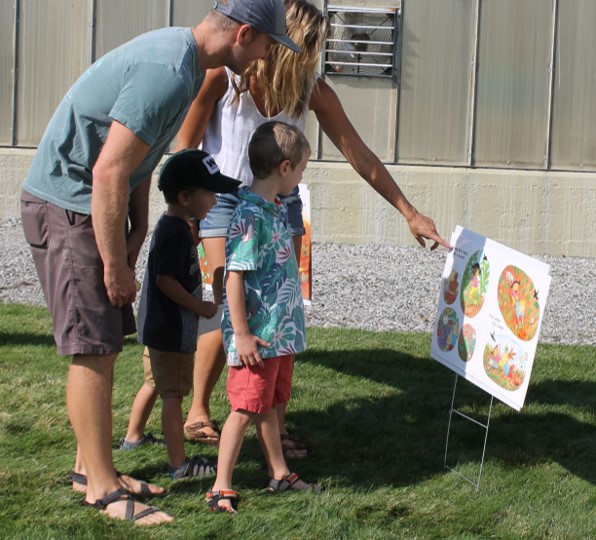 A family of four tours the story walk.