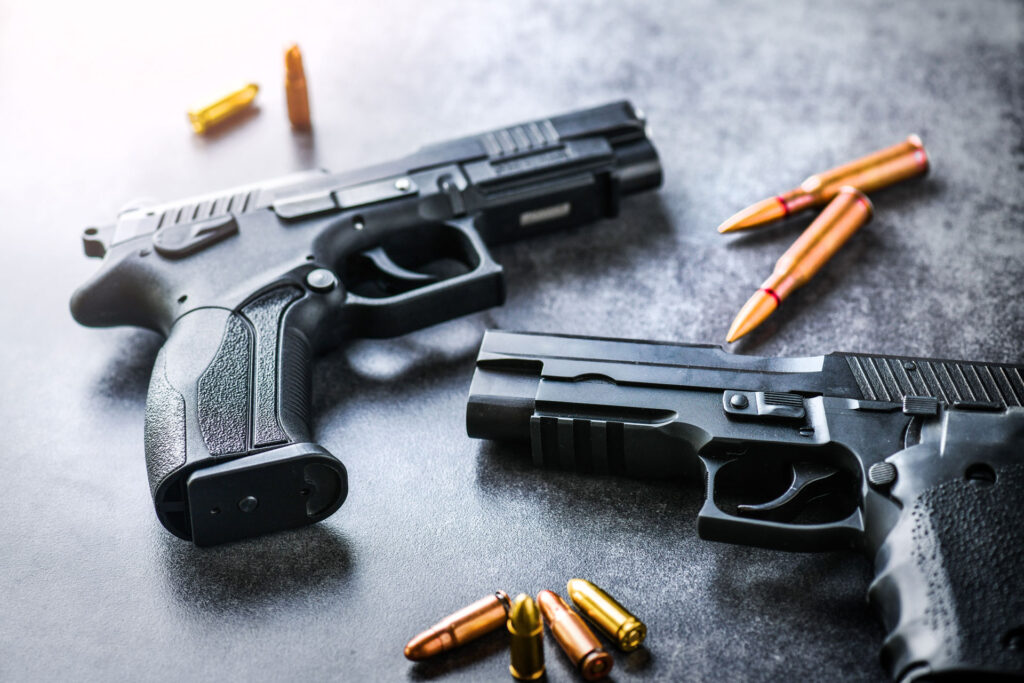 Two firearms and eight bullets on a table.