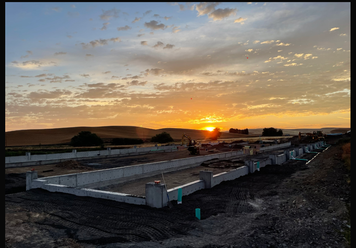 Building construction and equipment at sunrise.
