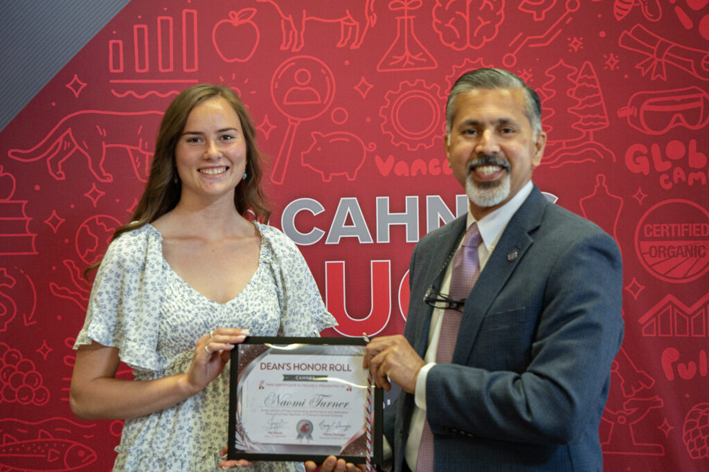 Naomi, left, and Khosla, right hold a framed certificate with Turner's name, reading "DEAN'S HONOR ROLL"
