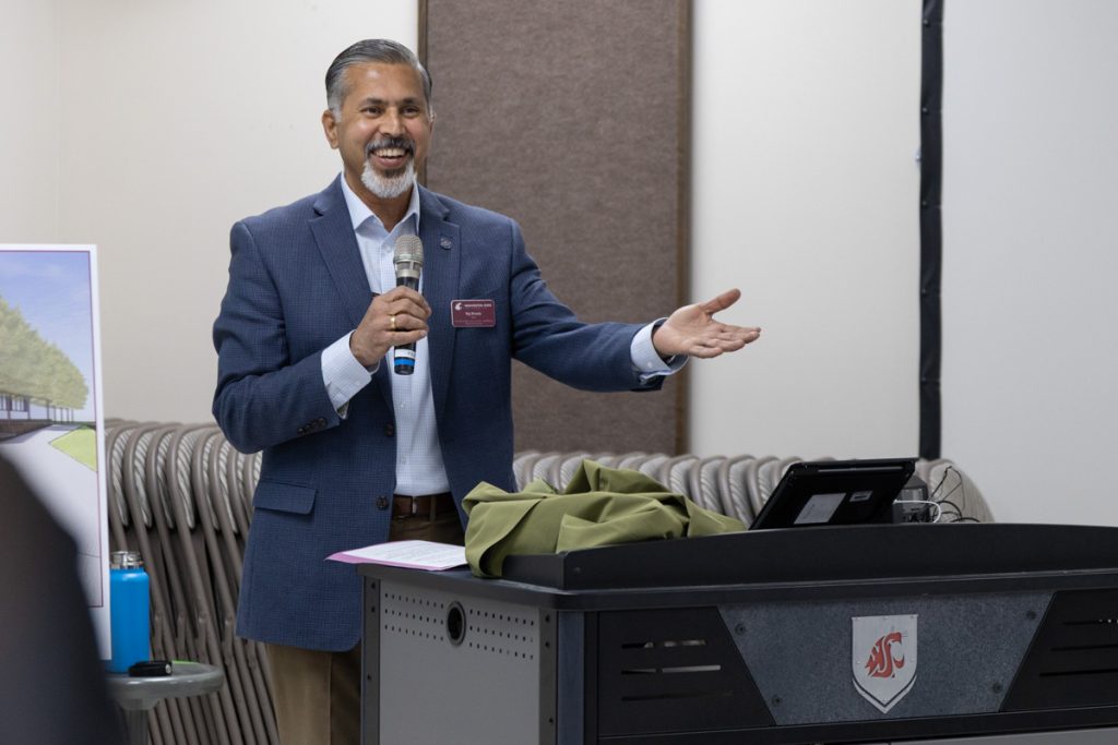 Dean Khosla gestures while holding microphone