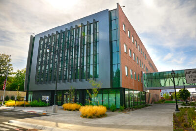 A building with a prominent glass facing. A sign on the building has the USDA logo and the words Plant Bioscience Research.