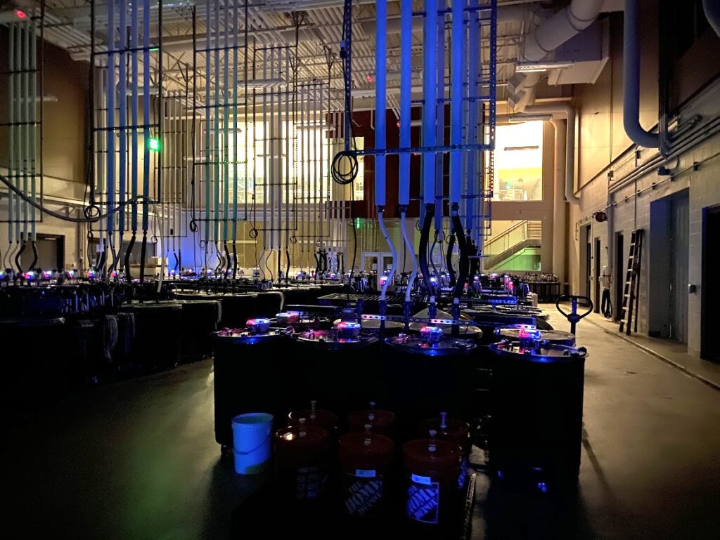 Tanks, pipes, and other winemaking equipment pictured in a dim room of the WSU Wine Science Center.