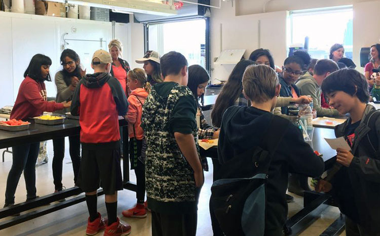 Graduate students conduct a lesson on "Measuring Sweetness of Fruit" for K-12 STEM students.