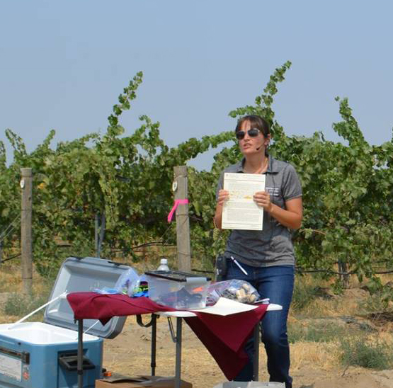 Michelle Moyer makes a presentation in a vineyard.