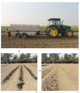 Tractor in a field with a trailer distributing biochar