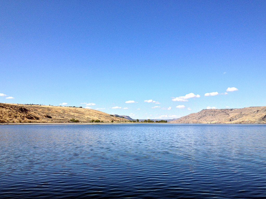 Lake surrounded by sparsely vegetated hills