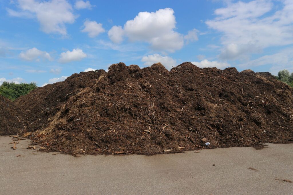 Compost piles beneath a blue sky