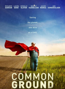 Poster from the movie Common Ground. There is a field with brown dirt on the left side and green grass on the right side with a blue sky in the background. A farmer leaning on a shovel and wearing denim overall and a red cape is standing on the grass side of the field.
