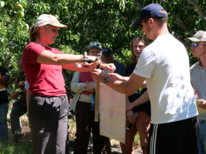 Molly Sayles at an outreach demonstration in an orchard.
