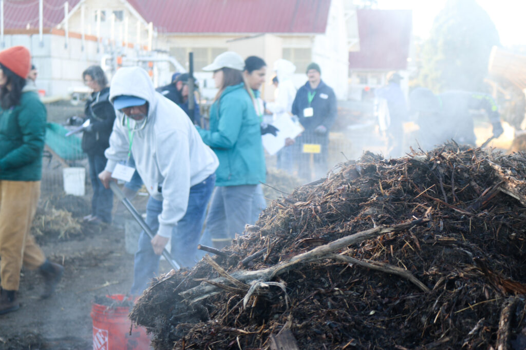 CFOT participants build a steaming compost pile.