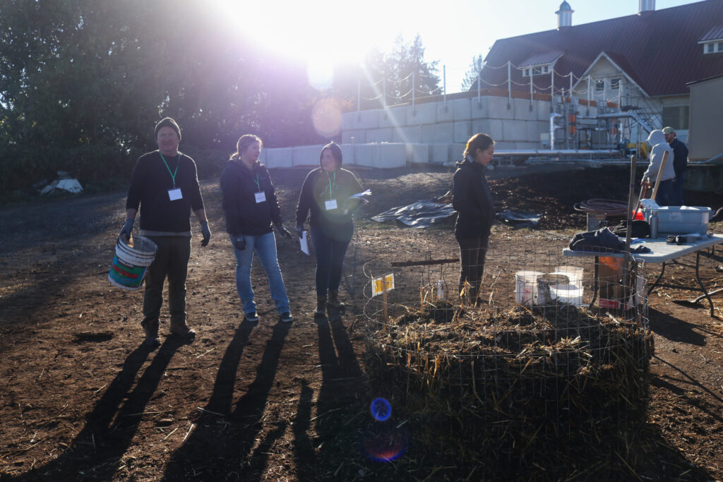 A group of people working on compost heaps.