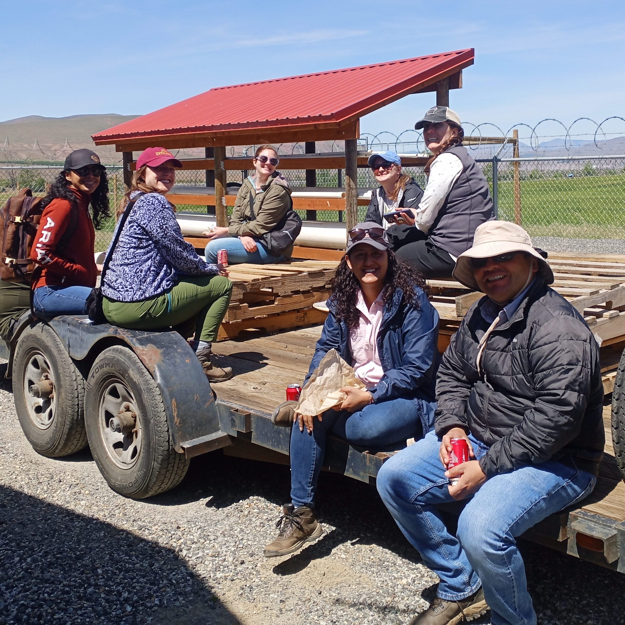 People sit on farm equipment.