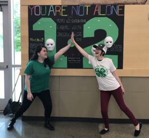 Image of a youth and adult high-fiving.