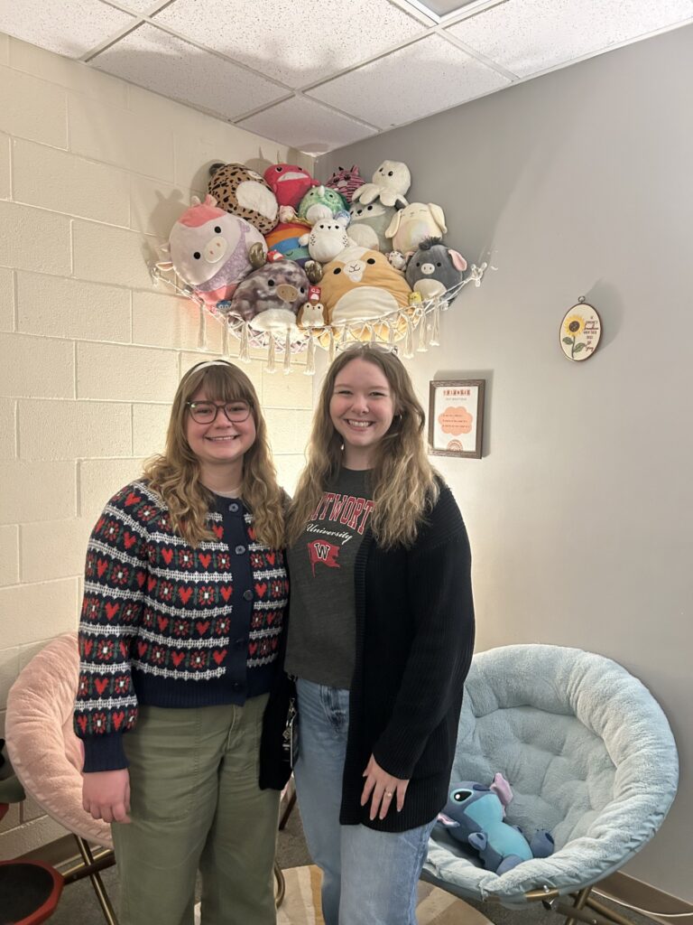 Two people standing together smiling at the camera.