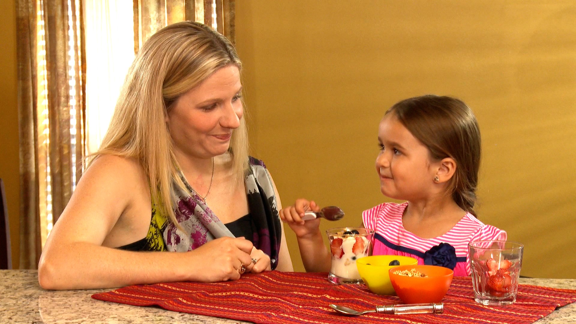 Mother serving child snack.