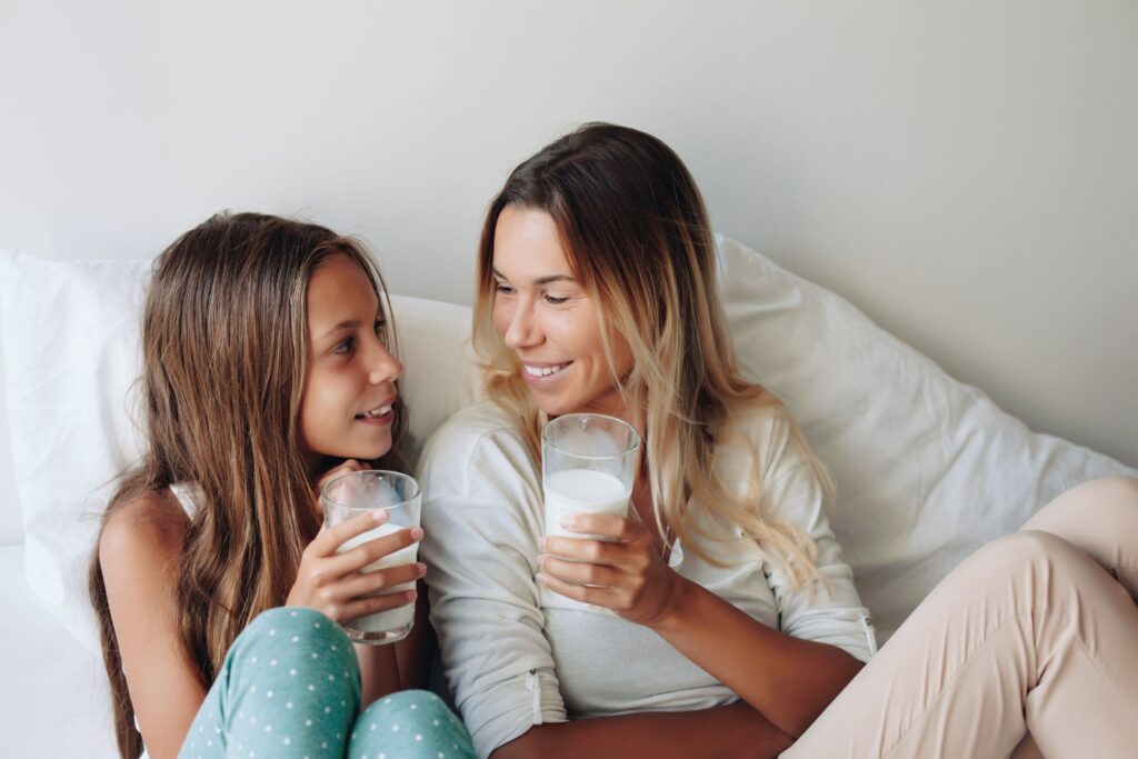 Mother and Daughter sitting next to each other drinking milk