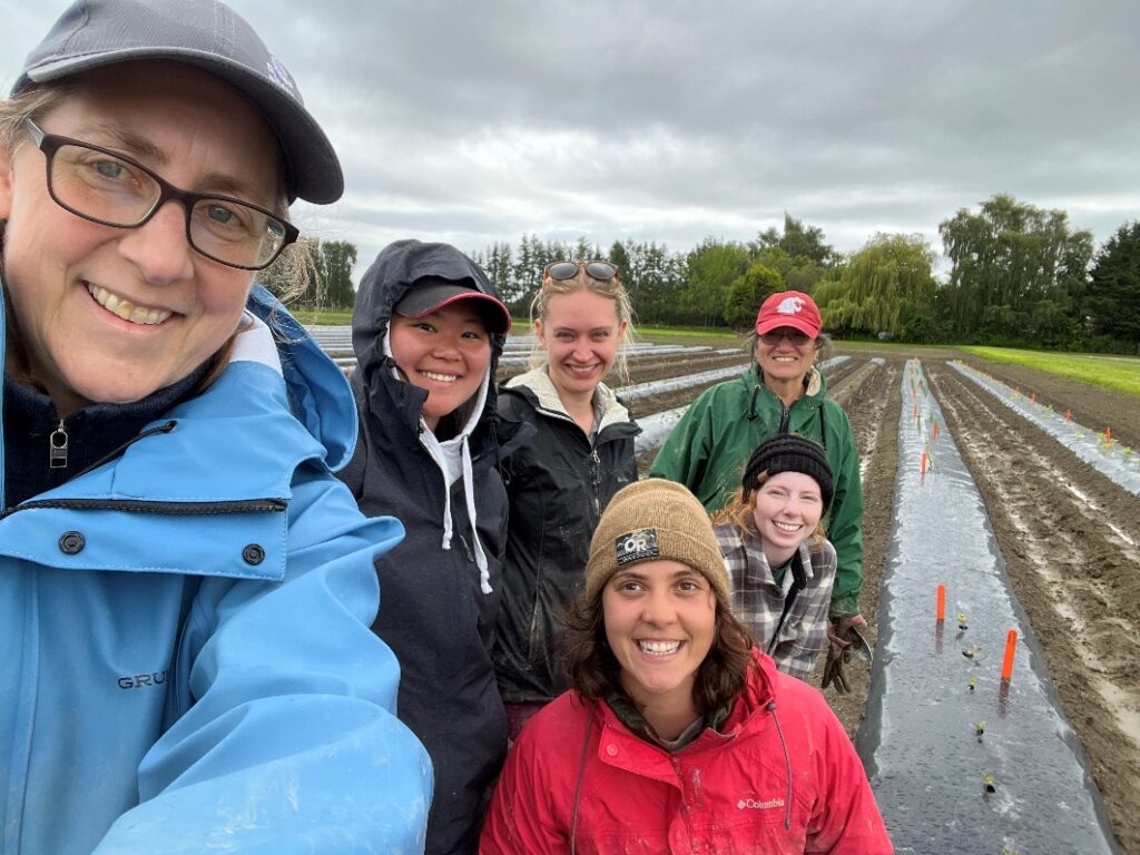 Six people taking a selfie in a field.