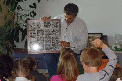Rich Zack displays a drawer of insects to a student group.