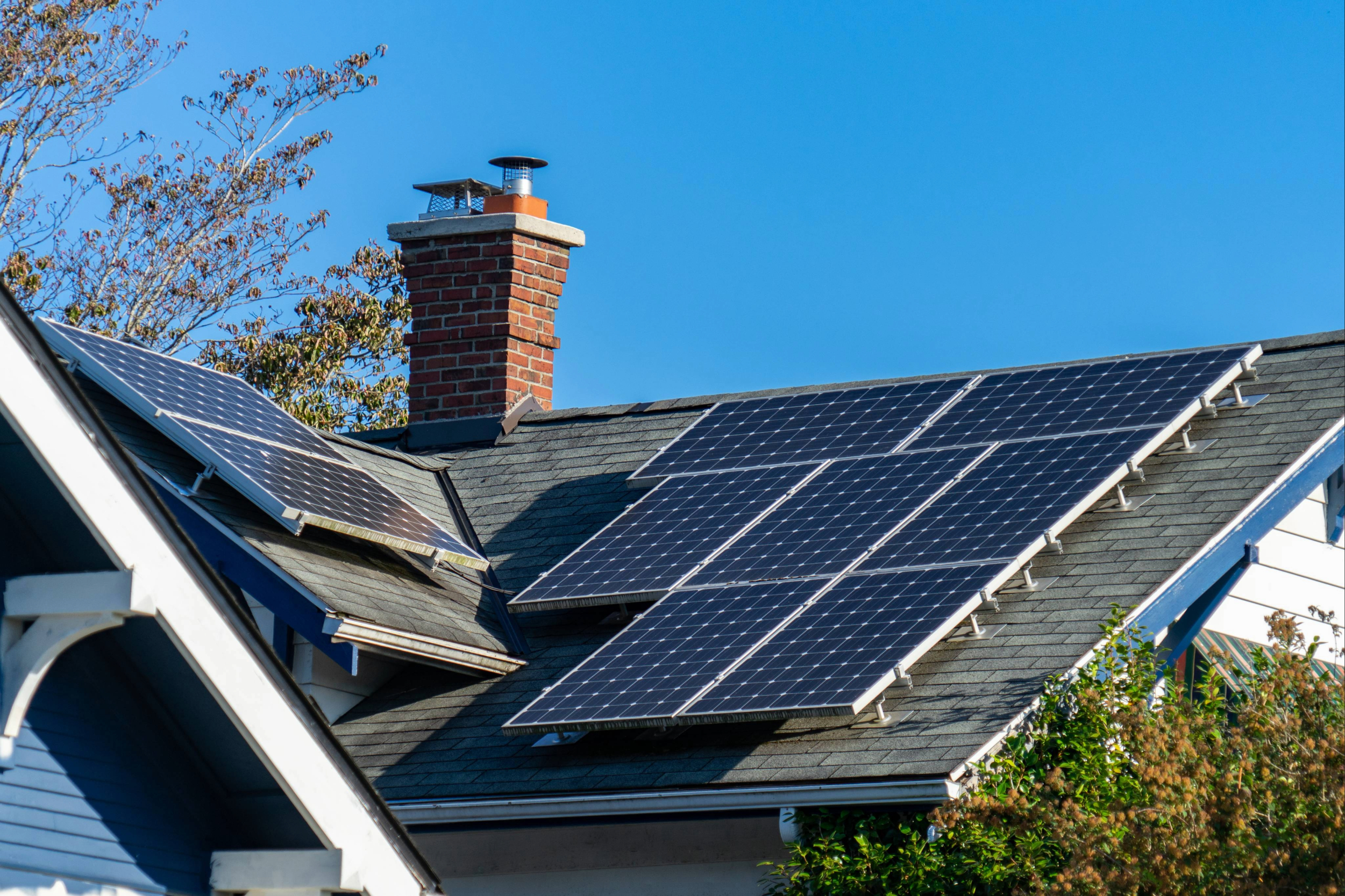 Solar panels at different angles on the roof of a residential home.