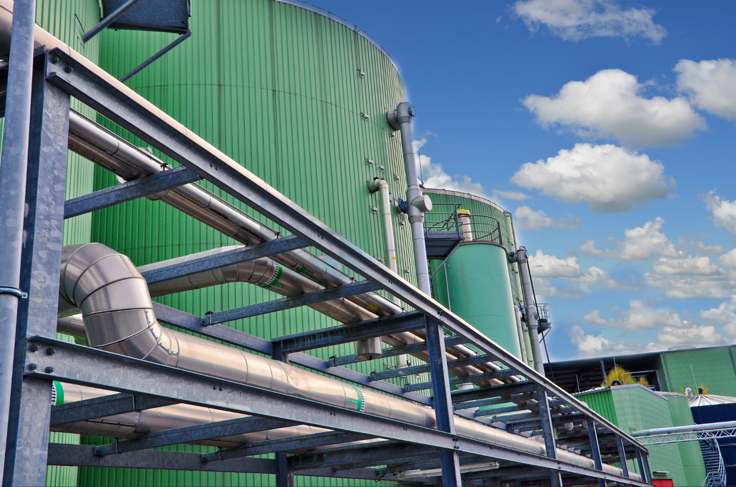 Green biogas tanks with pipes connecting them