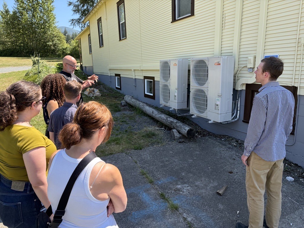 Morgan Nielsen and Erika Coveny of the WSU Energy Program stand with a group of listeners at a site visit to Opportunity Council