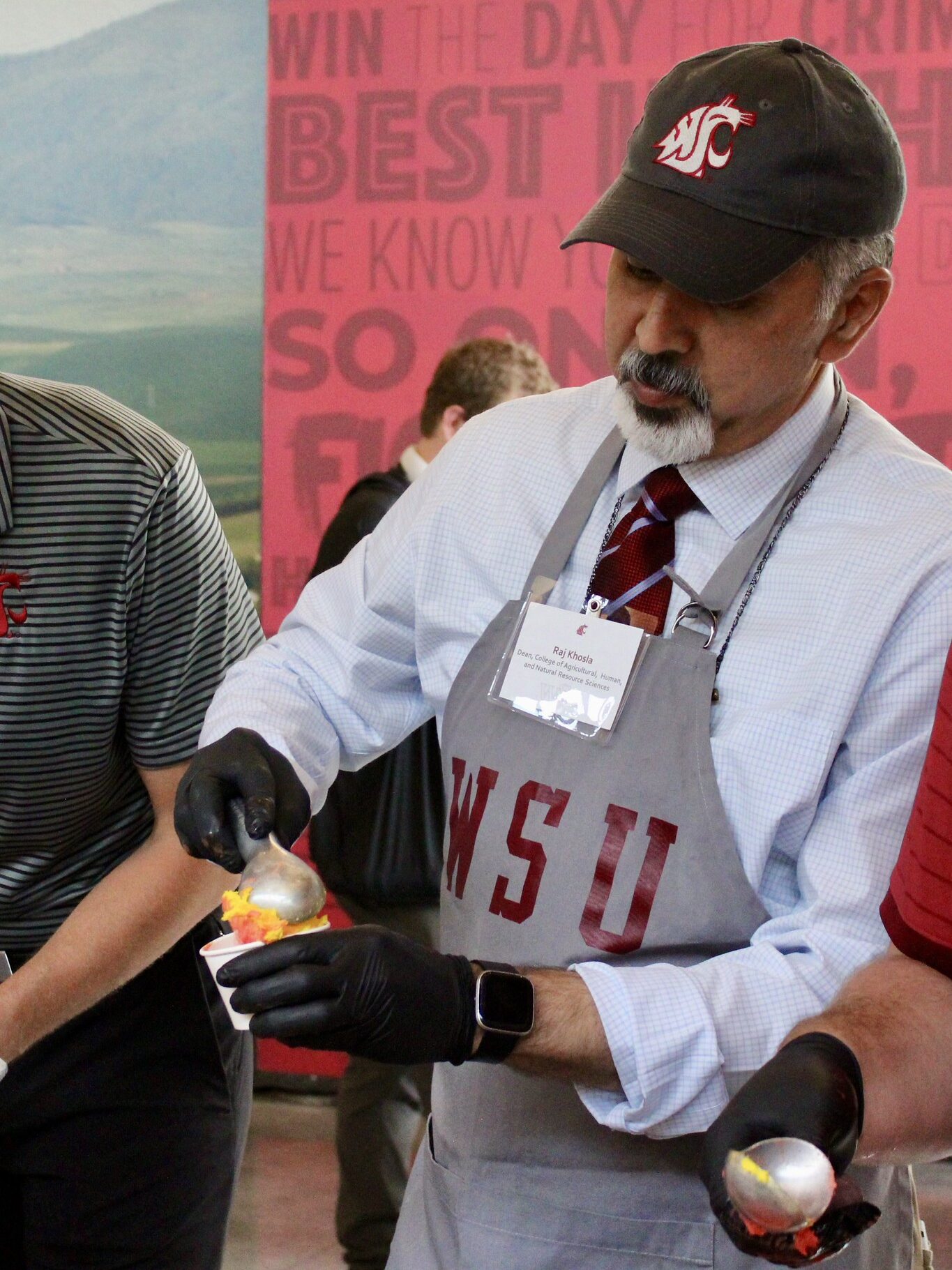 Raj Khosla scoops ice cream into a paper cup.