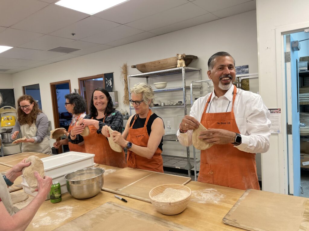 Raj Khosla and several others hand pizza dough in the Bread Lab kitchen.