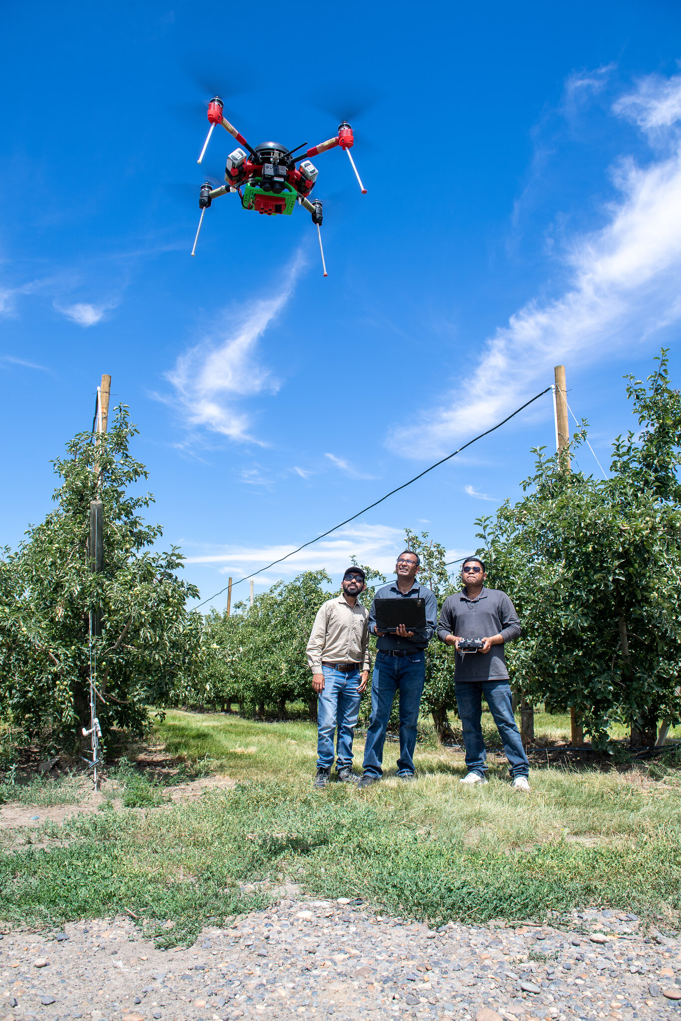 Three people flying a drone.