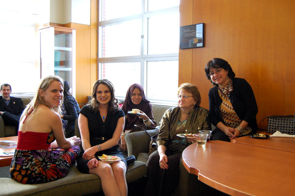 A group of people are seated together, smiling.