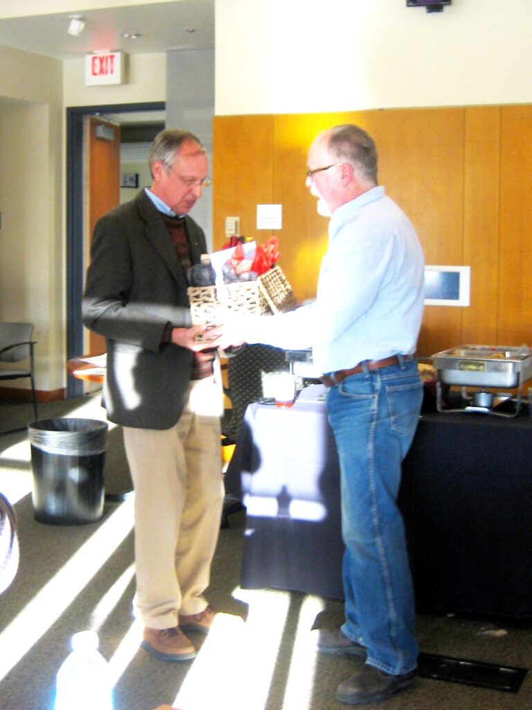 Dr. Shepphard hands off the basket full of stuff to Dr. Nijjout.