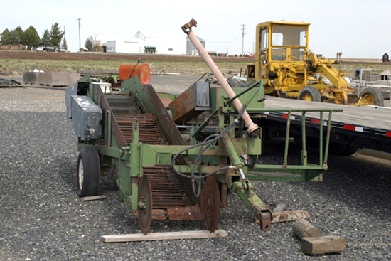 A picture of a one row potato digger and bagger.