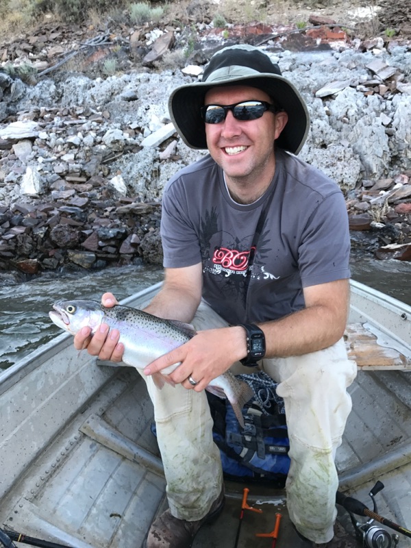 Rhett Spear, Ph.D., outdoors holding a fish he has just caught. Spear earned a doctorate in horticulture at Washington State University, graduating in 2015