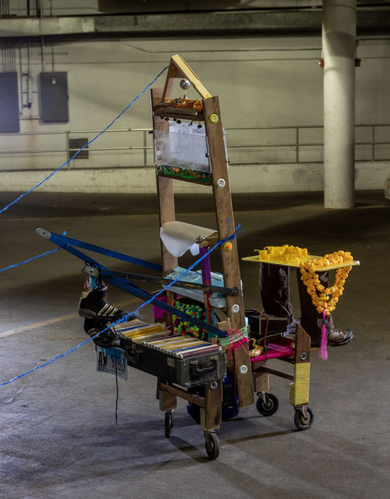 Multimedia sculpture build on an old loom with a variety of objects and materials attached. 