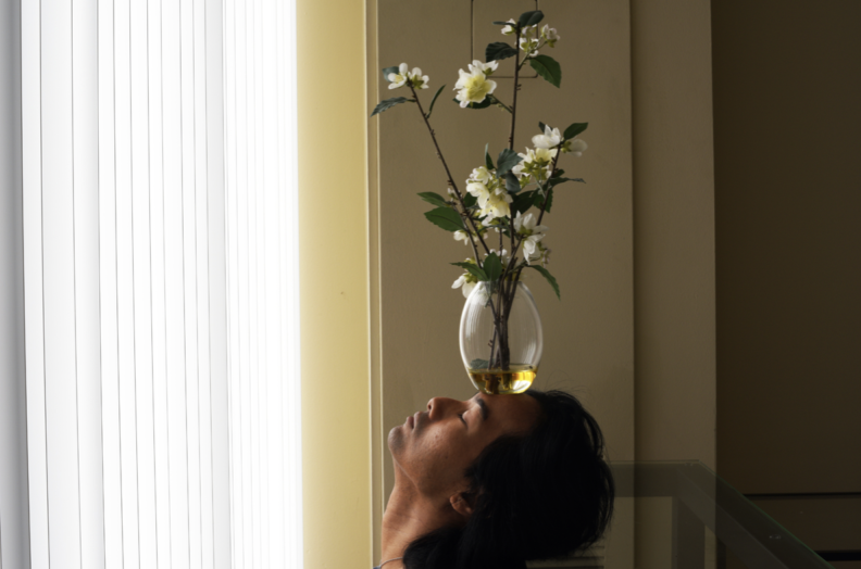 Person with vase on head.